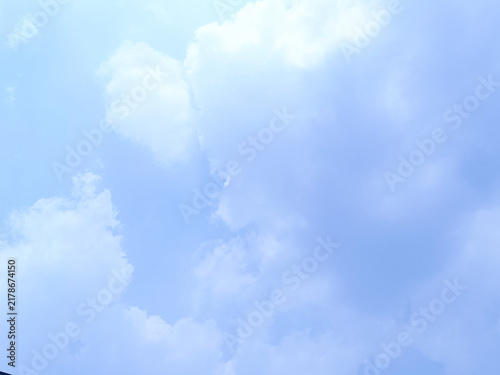 Fotografie Pale Blue Sky with Fluffy White Cumulus Clouds and Soft Glow