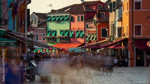 Burano Venice street timelapse with colorful houses, lively outdoor cafes, moving shadows, and flowing pedestrians during golden hour