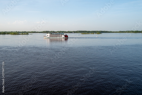 Canvas Print A passenger pleasure boat sails along the calm Volga River in Nizhny Novgorod, Russia, under a clear blue sky on a summer day