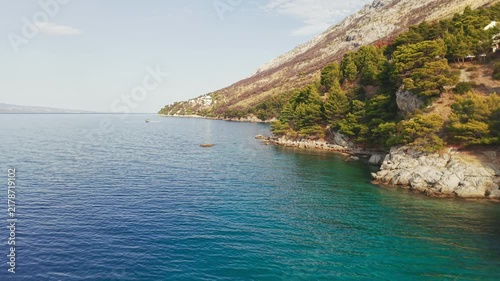 Picturesque Adriatic coastline with cliffs, pine trees and clear turquoise sea on a sunny summer day