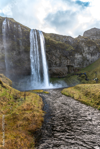 Seljalandsfoss waterfall in Iceland. Popular and beautiful waterfall along Route 1 and Ring Road. Seljalands River waters. Visitors can walk behind the falls and into cave. 