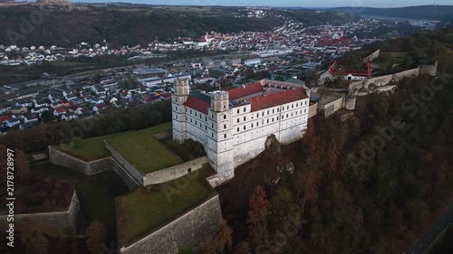 Cinematic aerial view of Willibaldsburg Castle in Eichstaett, Bavaria, Germany. Medieval fortress complex on hilltop, overlooking the Altmuehltal valley, old town, and surrounding natural landscape.