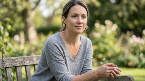 Serene Woman Reflects Peacefully While Seated Outdoors In A Lush Garden Setting