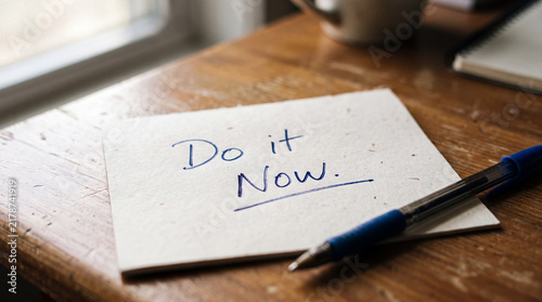 Do it Now text written on paper note for motivation and productivity concept