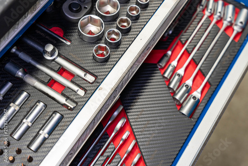 Foto Metal sockets and ratchet handles rest in lined toolbox compartments
