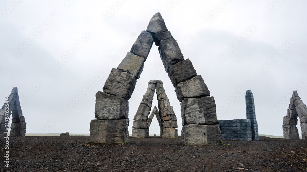 Obraz premium A massive modern stone monument at Arctic Henge overlooking the remote village of Raufarhöfn in northern Iceland.