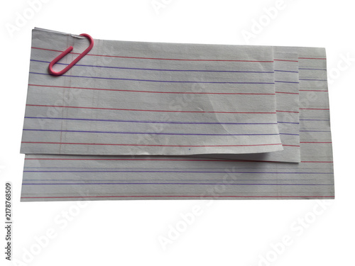 Stack of grey lined paper sheets held together by a single red metal paper clip on a flat surface