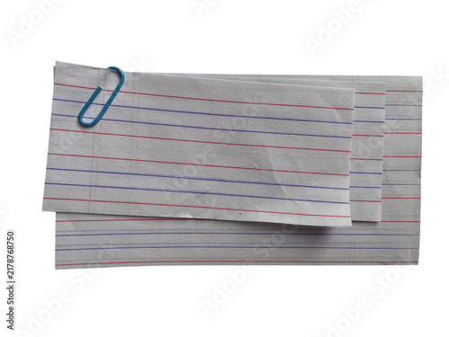 Stack of grey paper sheets with red and blue dash patterns held together by a single small metal paper clip