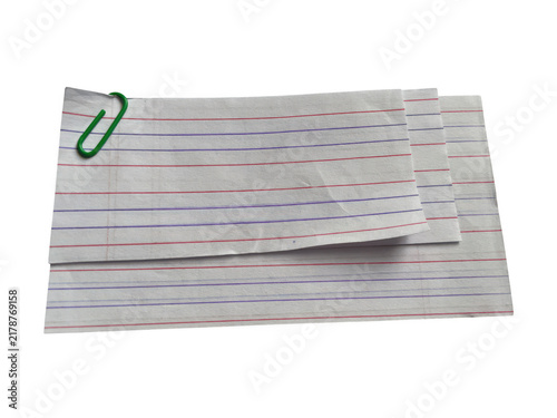 Stack of white paper sheets with red and blue vertical lines held together by a green metal paper clip