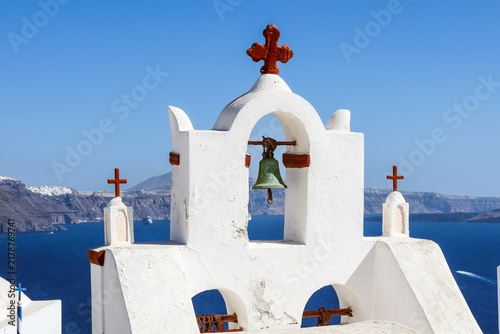 Fotografie Whitewashed bell tower above a blue caldera