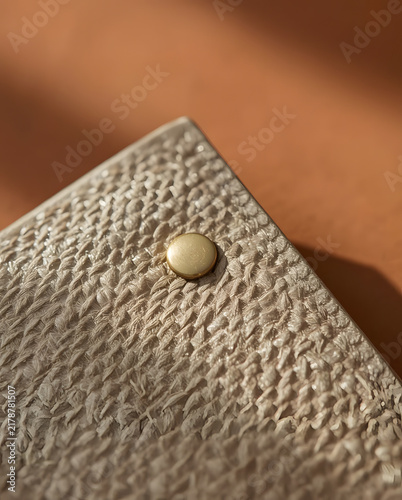 Close up of beige textured leather wallet with gold snap button
