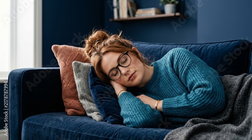 Relaxed indoor scene featuring a woman with glasses resting her head on pillows.