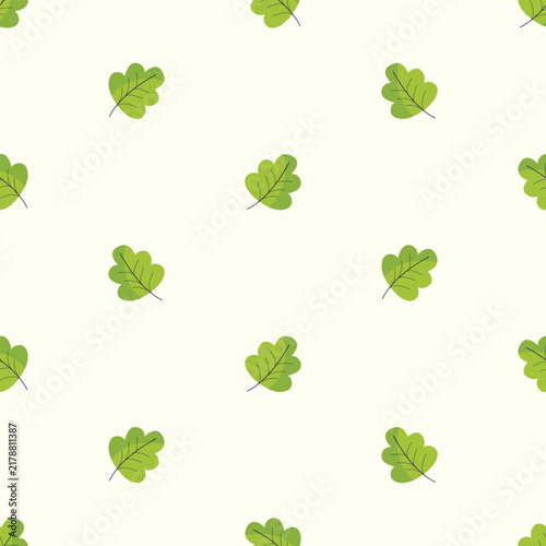 Green oak leaves forming a seamless pattern on a cream background