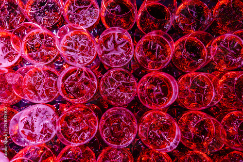 Canvastavla Close-up view of numerous transparent cups filled with vibrant red liquid and ic