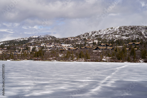 Norefjell Winter Scene: Frozen Lake and Rustic Mountain Cabins