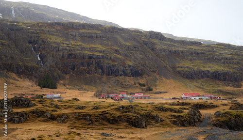 Remote Icelandic Village and Farm Houses Nestled Under Steep Basalt Mountain Cliffs