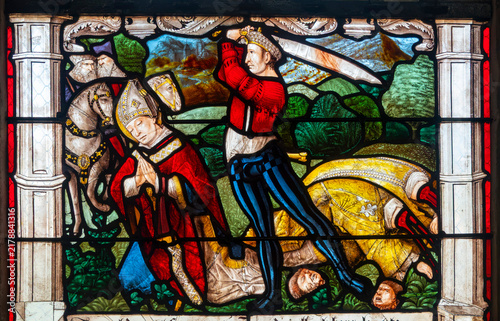 A medieval stained glass panel depicts the Martyrdom of Saint Denis of Paris.