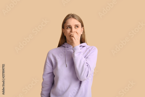 Принти на полотні Young woman feeling bad smell on beige background