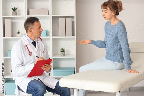 Mature doctor working with patient in medical office