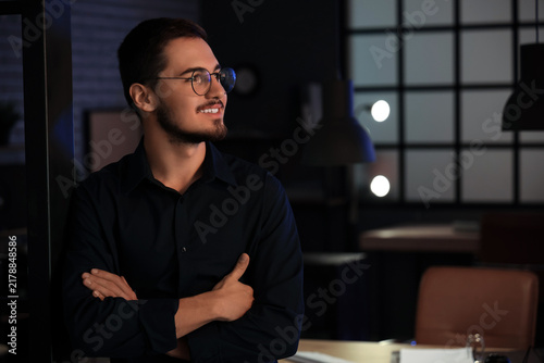 Handsome young man in office at night