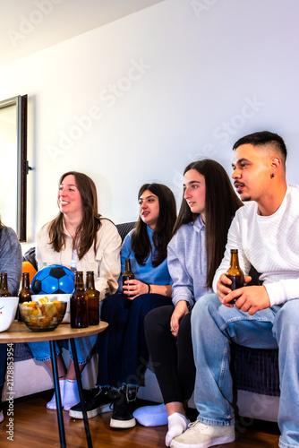 Foto Young friends enjoying a soccer match at home, celebrating sports and friendship
