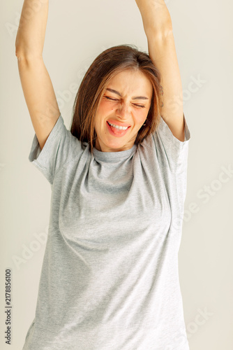 фотографія Young woman laughing with her eyes shut and arms up