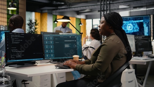 Obraz na plátne Engineer in an office uses an AI LLM chatbot to optimize performance, while the IT employee works with a generative artificial intelligence assistant for faster software development