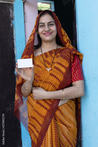 Canvas Print Portrait of Indian rural young woman showing unique identity card at village