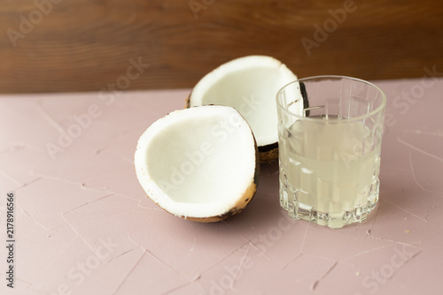 Pouring fresh coconut water from a cracked coconut into a clear glass