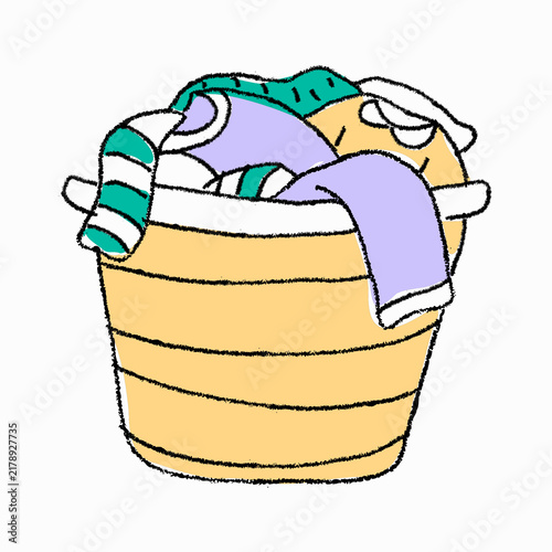 Fotografía A tall woven laundry hamper overflowing with colorful folded clothes and washed garments ready to be folded or put away