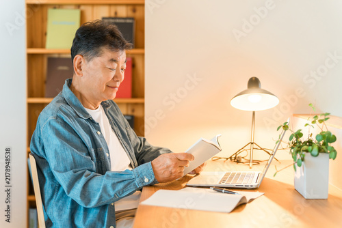 Принти на полотні A senior man reading in his home study.
