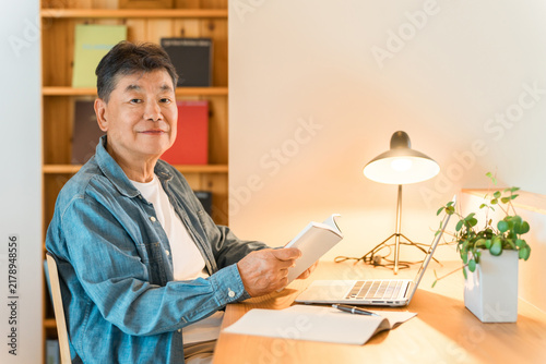 Принти на полотні A senior man reading in his home study.