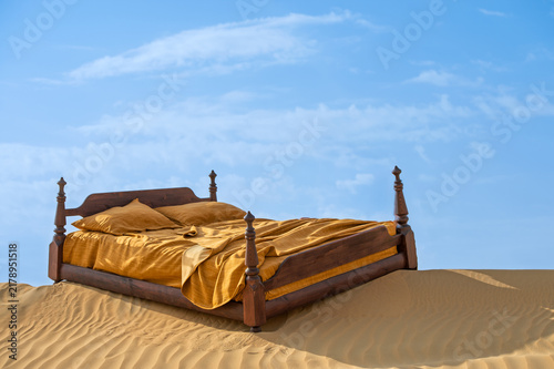 Foto large double bed on the sand in the desert for background