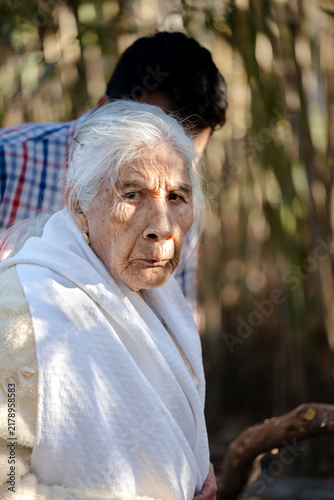 Konstfotografi Portrait of an elderly woman with white hair and wrinkled skin in a shawl outdoo