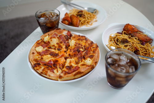 Obraz na plátně High Angle Perspective Shot of Pizza, Spaghetti, Fried Chicken, and Iced Cola on White Table