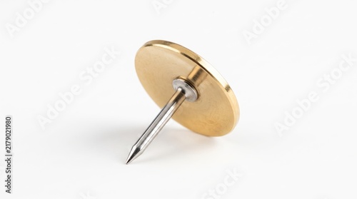 Plakat A single brass push pin sitting on a flat surface