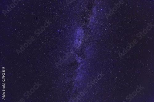 Canvastavla A dark night sky filled with countless faint stars, showing the bright band of the Milky Way stretching across space