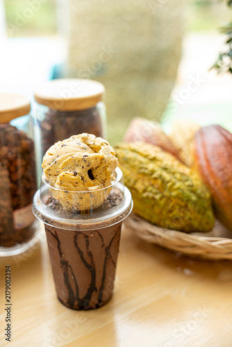 Paper cups with tasty chocolate ice cream on wooden table, closeup