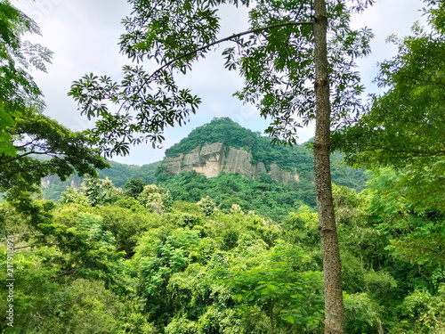 Fotografie Majestic green mountain peak with steep rocky cliff side