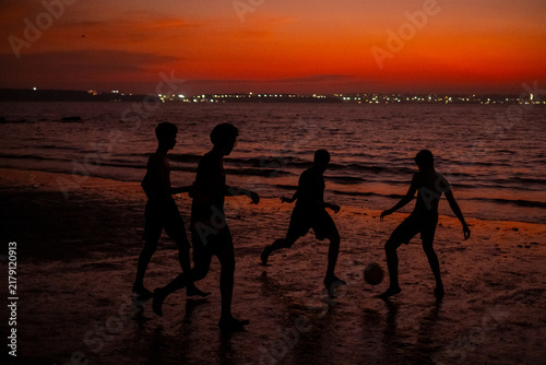 people on the beach at sunset in Goa playing Football