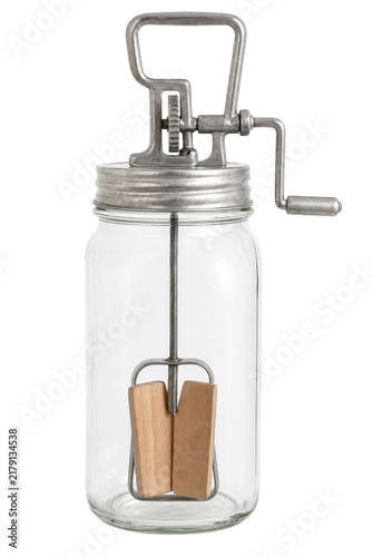 Fotografie Vintage glass butter churn with a metal lid and wooden paddles, photographed on