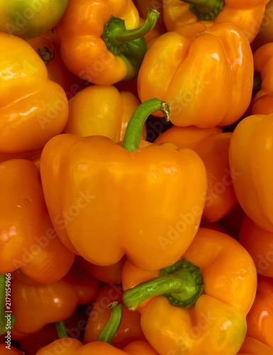 Obraz na plátně Full frame top view close up shot of fresh orange bell peppers with green stems closely packed together