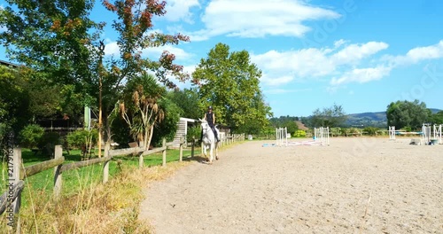 Beautiful young girl on a white horse at an equestrian farm