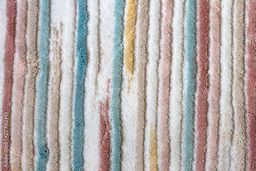 Carpet surface with vertical colored stripes. Fabricated carpet texture. Fabric or woven background. Wallpaper. Top view, above, up. No people, nobody. Horizontal photo. Pattern.