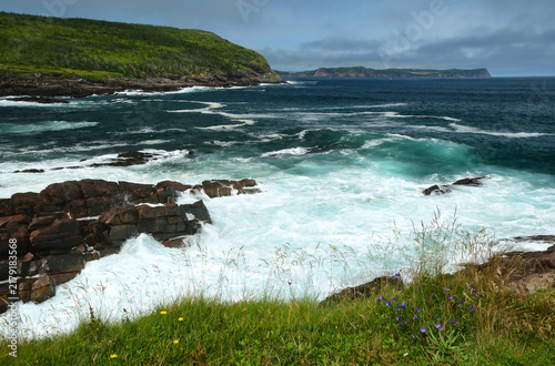 looking out across the   dangerous waves and rocky coastline of st. john's bay towards the headlands of St. John's  in summer  from cape spear, newfoundland, canada