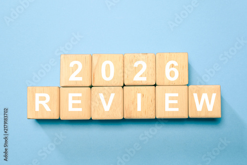Obraz na plátně Wooden blocks spelling 2026 REVIEW on a blue background, representing year-end review, annual report, business performance, reflection, evaluation, strategic planning, goals, and progress
