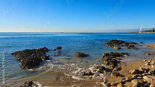 Quadro su tela Clear blue sky above the Atlantic Ocean, featuring a sandy and rocky coastline w