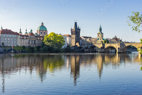Foto Charles bridge and historic prague waterfront reflecting vltava river