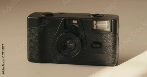 Vintage black 35mm point and shoot compact film camera on neutral table