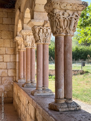 Foto Romanesque cloister featuring ornate carved stone capitals and arches